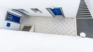 מבט עילי על קומת מגורים יוצר חגיגה גרפית של צורות וקווים. ריצוף, מדרגות, דלתות וחלונות מופשטים משימושם המקורי ומתגלים ביופיים הגיאומטרי. תמונה מיוחדת בצבעים סולידיים המתאימה לסלון או למשרד בעיצוב מודרני