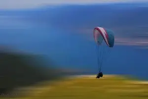 בין שמיים לארץ, בשקט ושלווה, תלויים על מצנח רחיפה ונהנים מהנוף והאויר הפתוח. התמונה צולמה גבוה מעל אגם גארדה ומתאימה להוספת רוגע ושלווה למשרד או לבית.